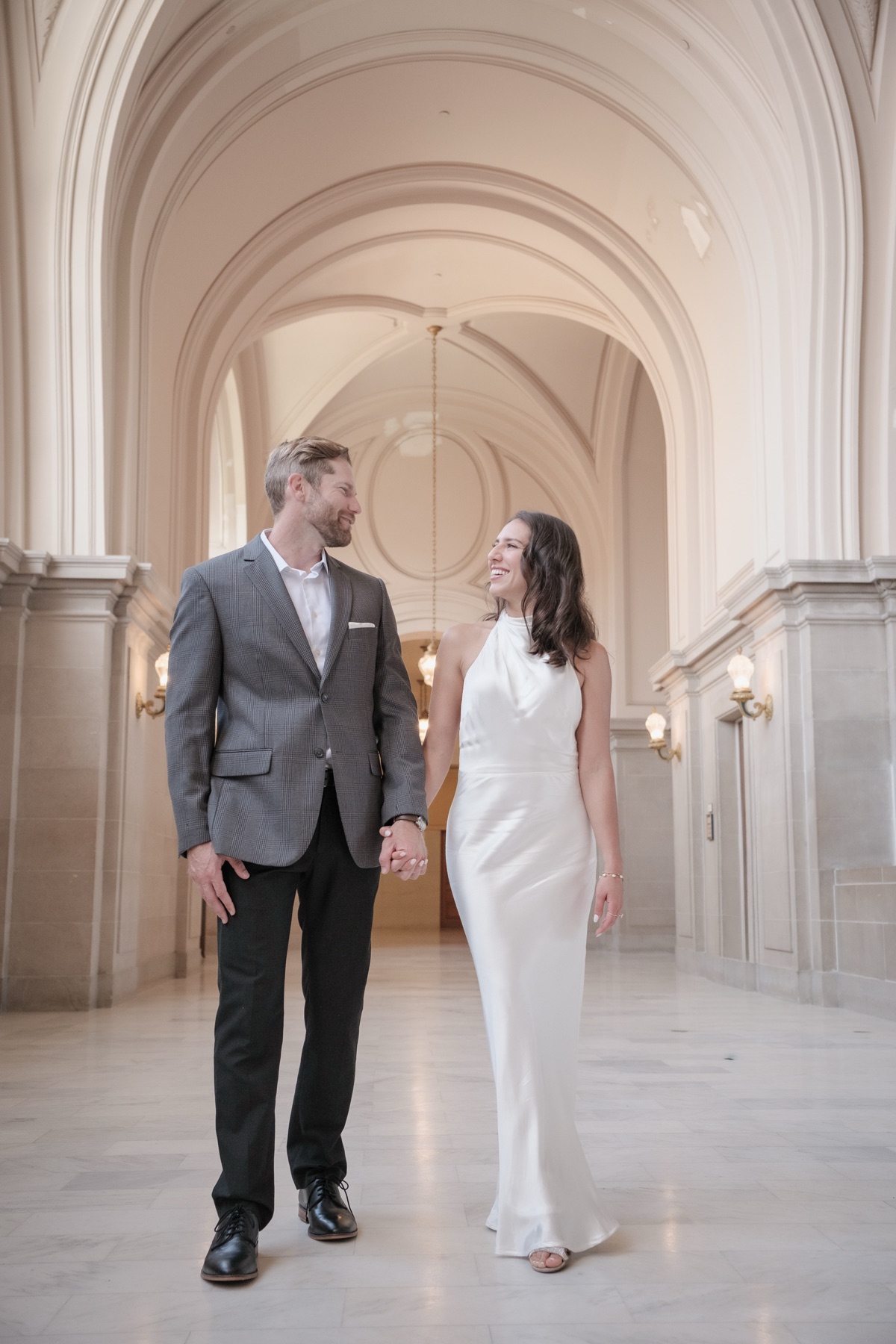 Couple embracing outside San Francisco City Hall in golden light, wedding photography by Matt Dea