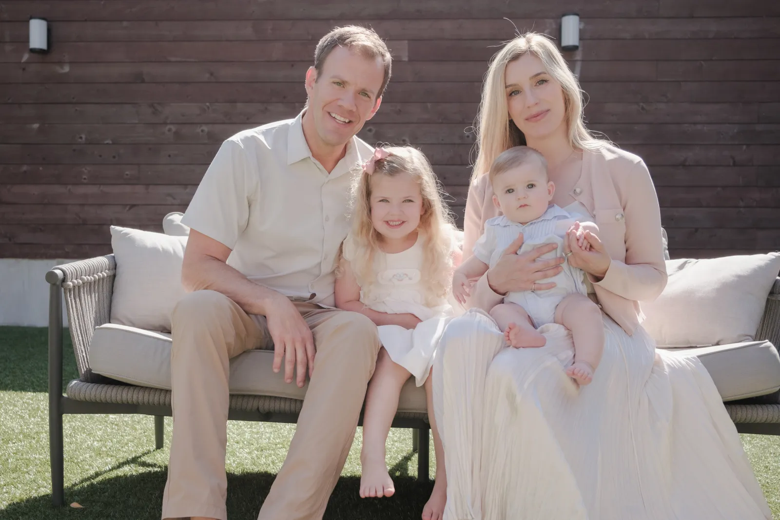 Family of four on an outdoor sofa in their backyard near Alamo Square, San Francisco