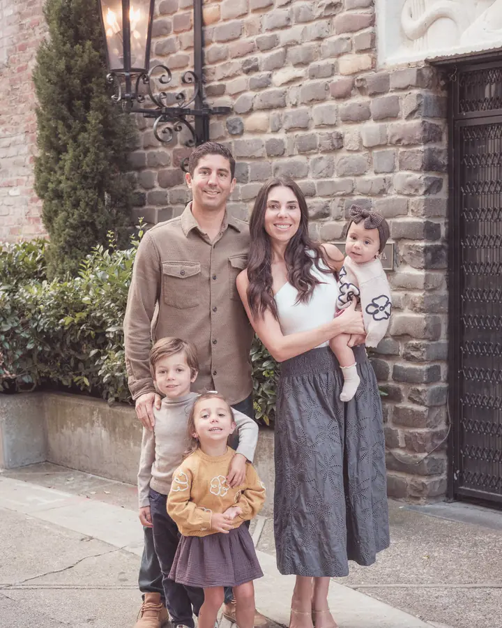 Family of five posing beside a historic brick building in Jackson Square, San Francisco