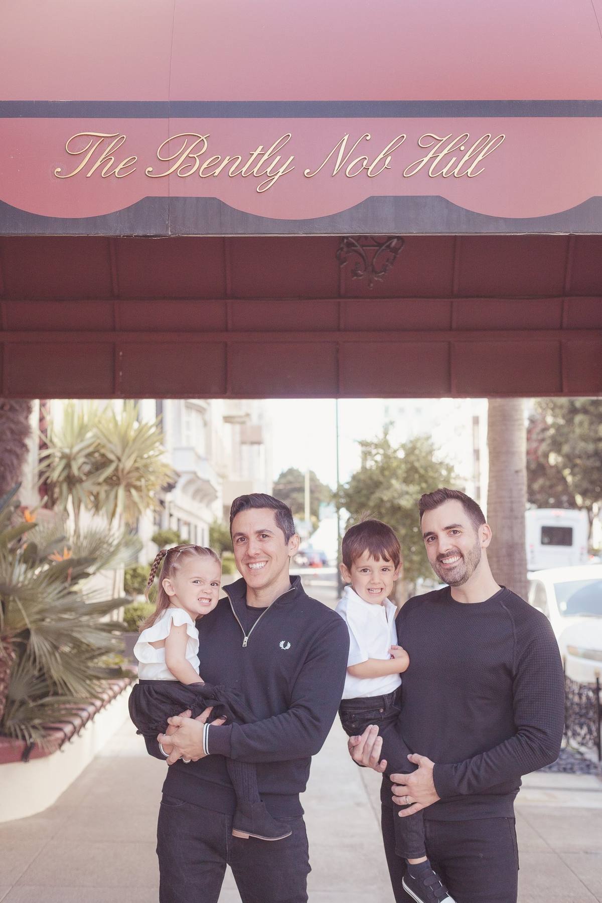 Family of four on the sidewalk outside the entrance to their Nob Hill building
