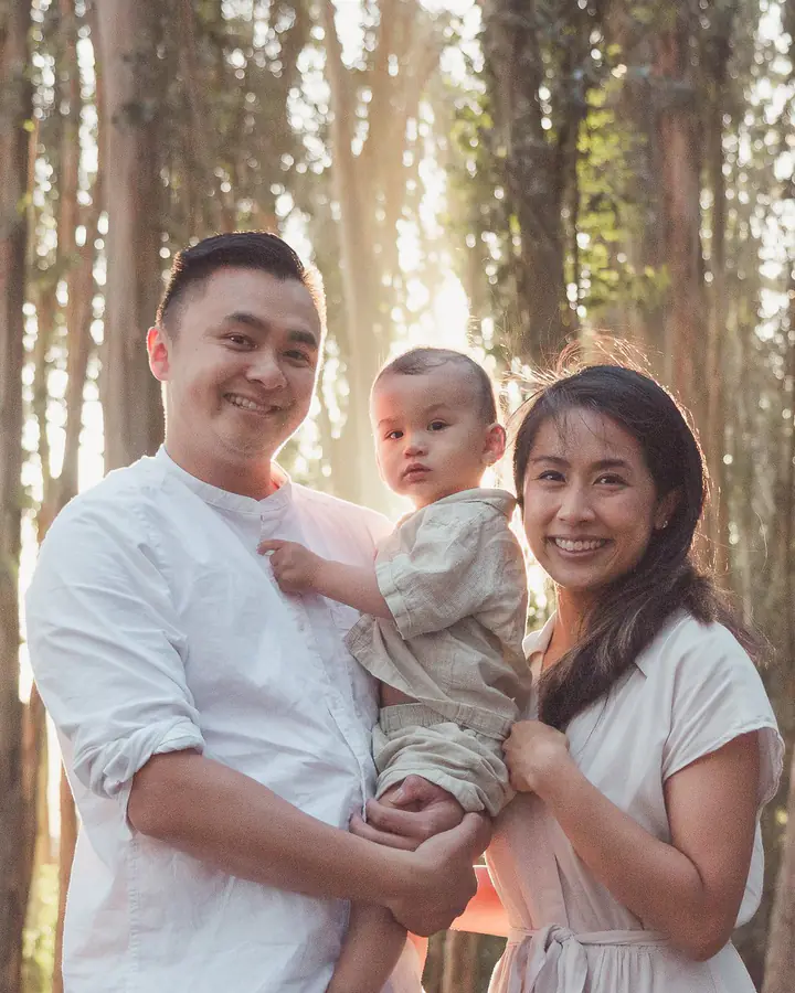 Parents holding their toddler in the eucalyptus grove at Andy Goldsworthy's Wood Line in the Presidio