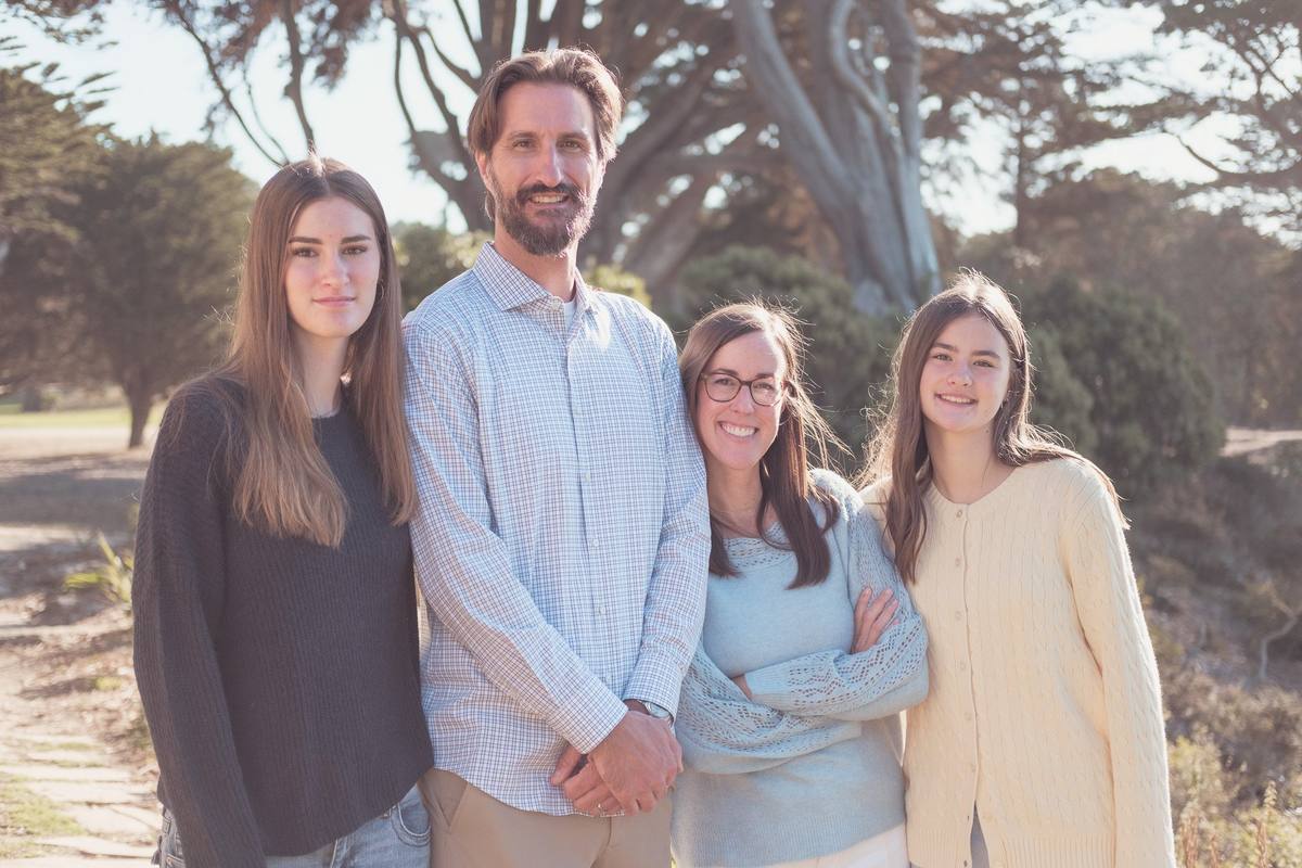 Family of four with two teenage daughters under the cypress trees at Sutro Park
