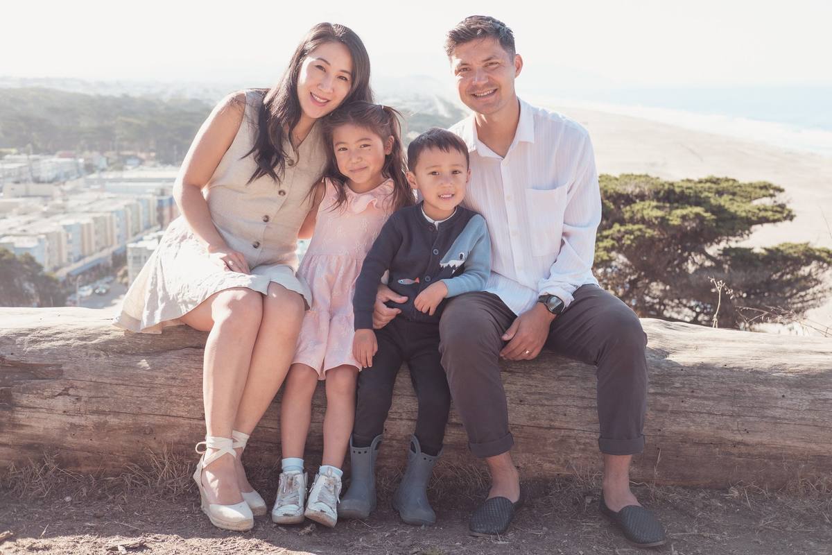 Family of four sitting on a log overlooking Ocean Beach at Sutro Park