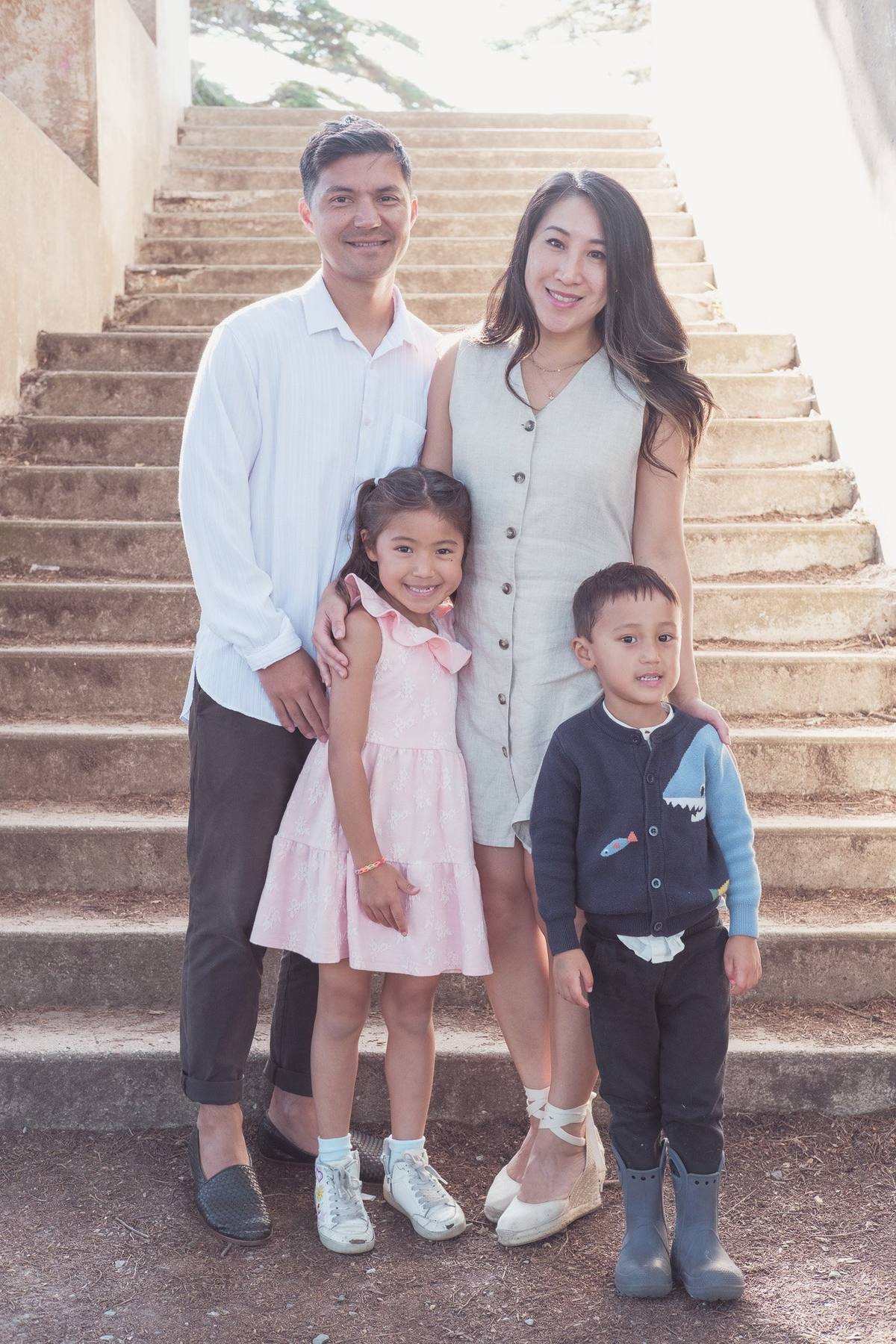 Family of four standing together on the stone steps at Sutro Park in San Francisco