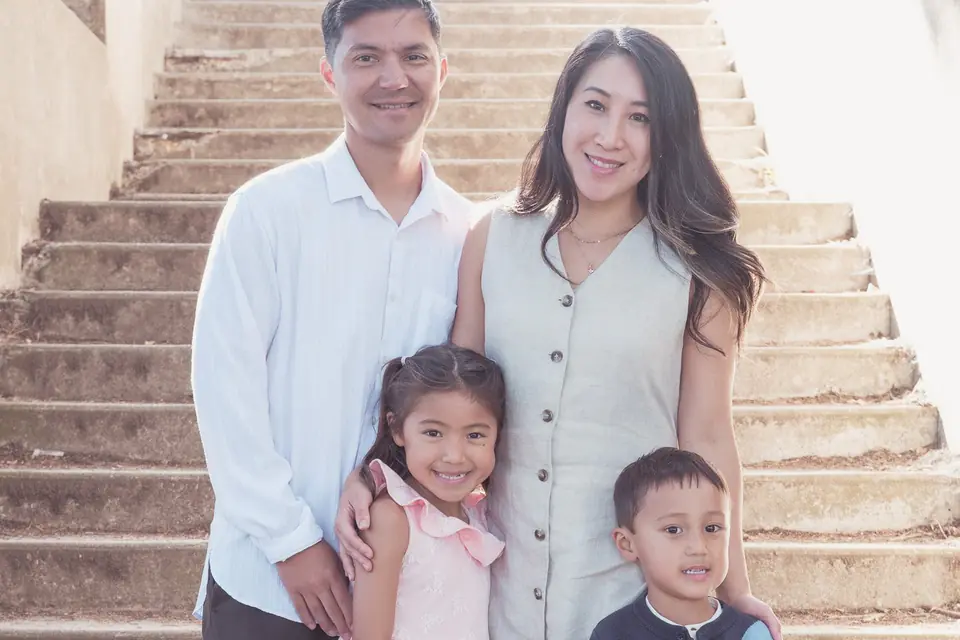 Family of four standing together on the stone steps at Sutro Park in San Francisco