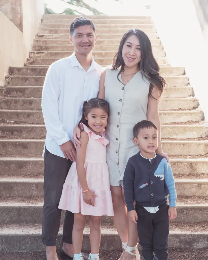 Family of four standing together on the stone steps at Sutro Park in San Francisco