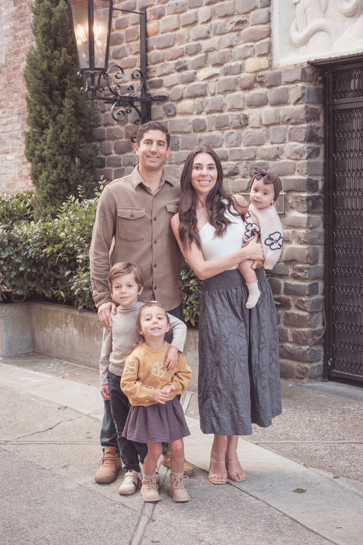 Family of five posing beside a historic brick building in Jackson Square, San Francisco