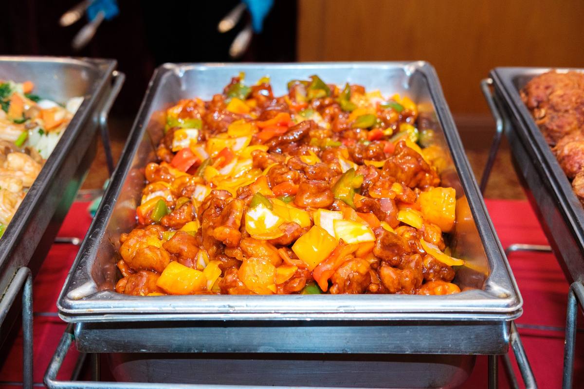 Buffet tray of sweet and sour pork with peppers and pineapple