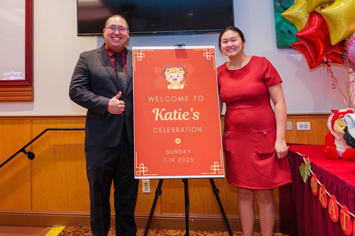 Parents posing beside the welcome sign for their baby's celebration