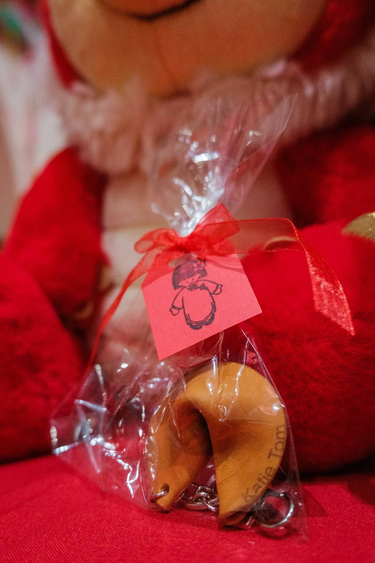 Fortune cookie favor wrapped in cellophane with a red ribbon