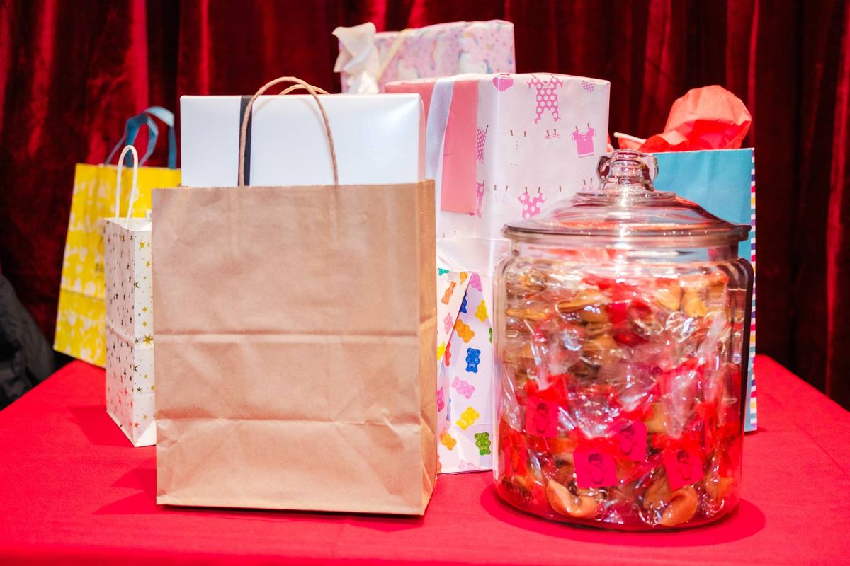 Gift bags and a jar of wrapped candies on the gift table