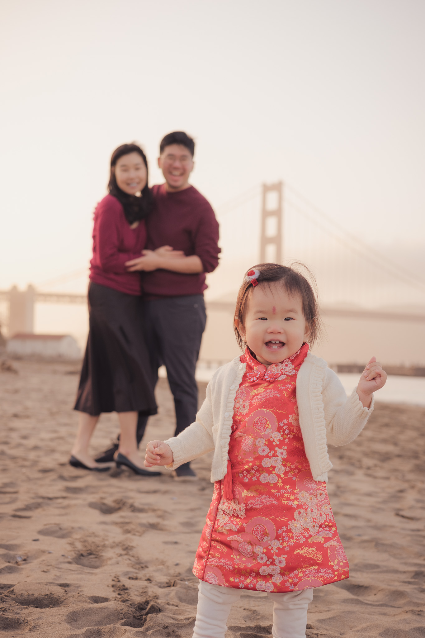 Family walking on the beach with the Golden Gate Bridge in view