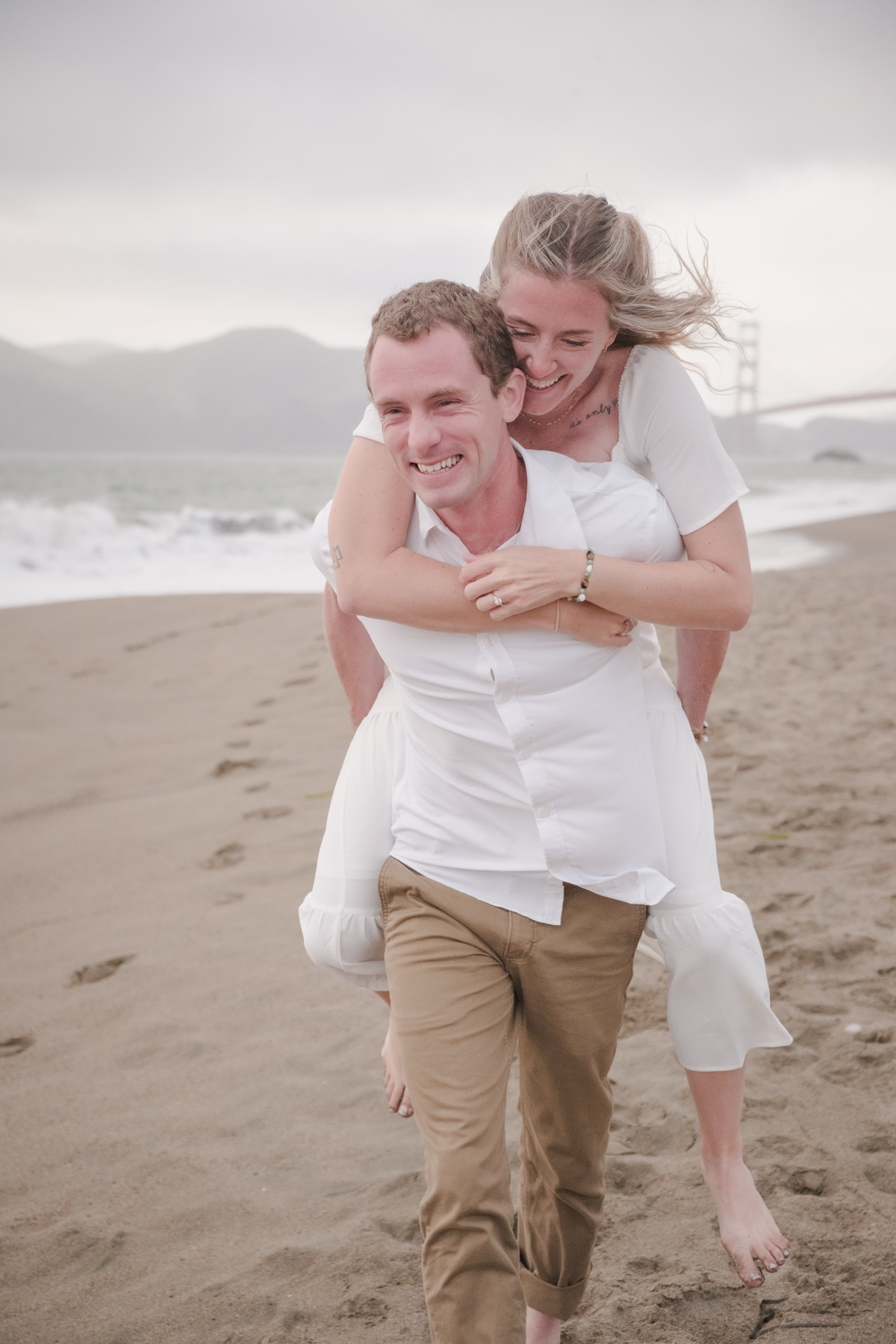Couple embracing during a golden hour engagement session at Sutro Baths, San Francisco — photography by Matt Dea