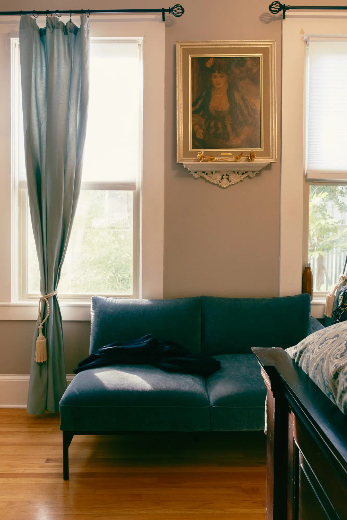 A blue velvet chaise under the window