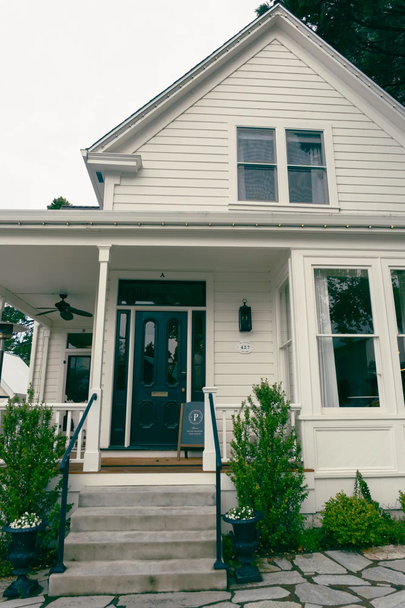 A white historic house with a front porch