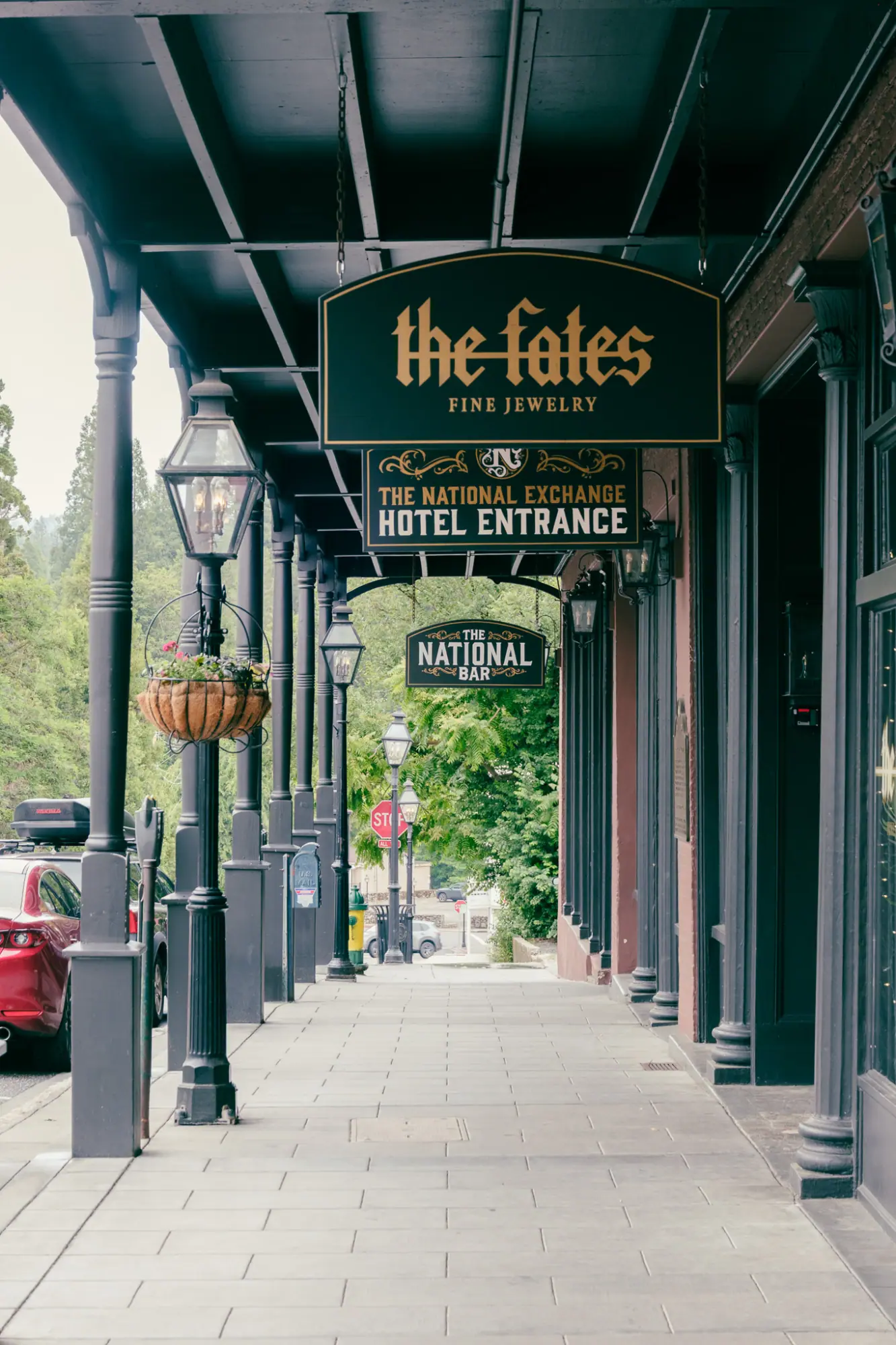 A covered sidewalk under a hotel entrance sign