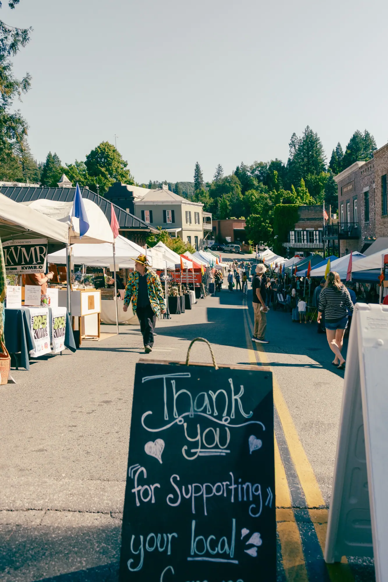 A thank-you chalkboard sign along the market