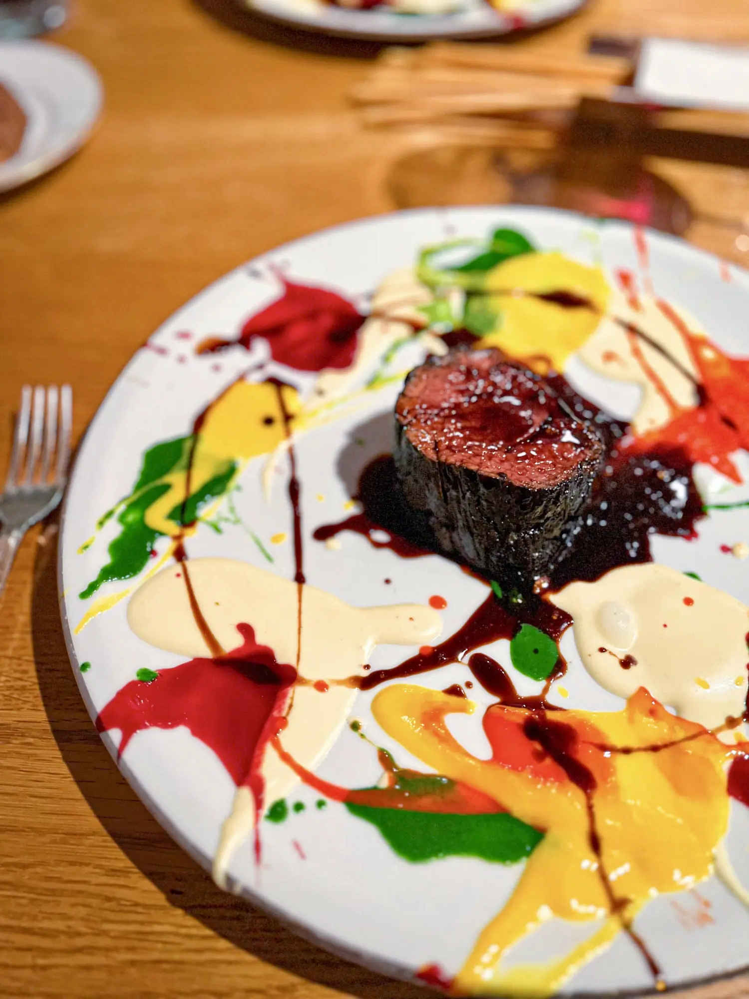 Beautiful Psychedelic, Spin Painted Veal Charcoal-grilled veal, glazed in flavor, served over a canvas of color. Inspired by Damien Hirst, painted with beets, carrots, herbs, and emotion. A dish that blurs the line between plate and palette.