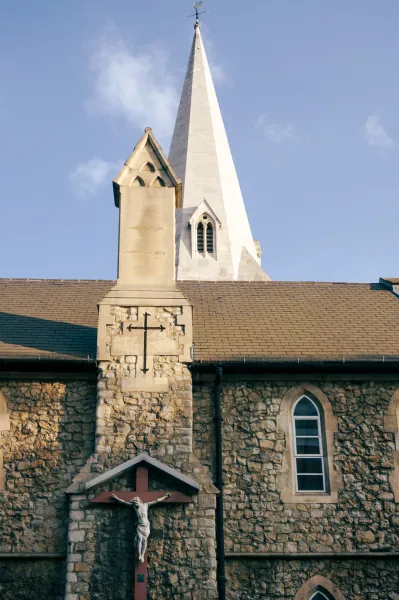 Flint-and-stone church gable with crucifix and white spire