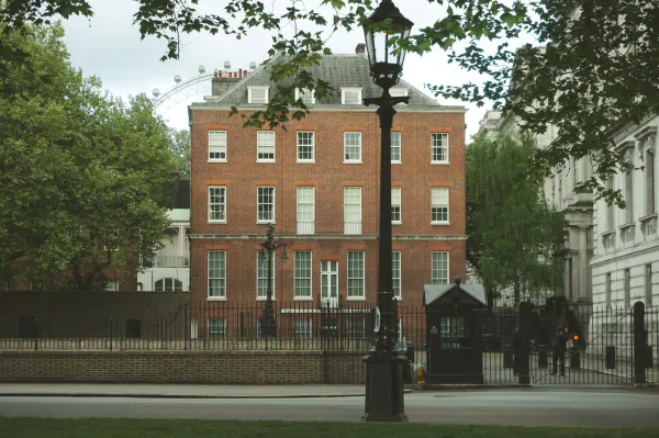 Red-brick house behind railings, London Eye behind