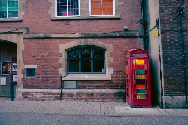 Red phone box beside a brick building