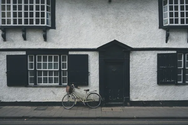 White house with black shutters and a bike