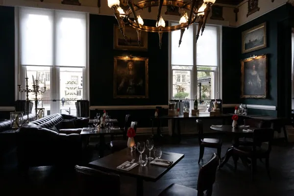 Dining room with chandelier and portraits