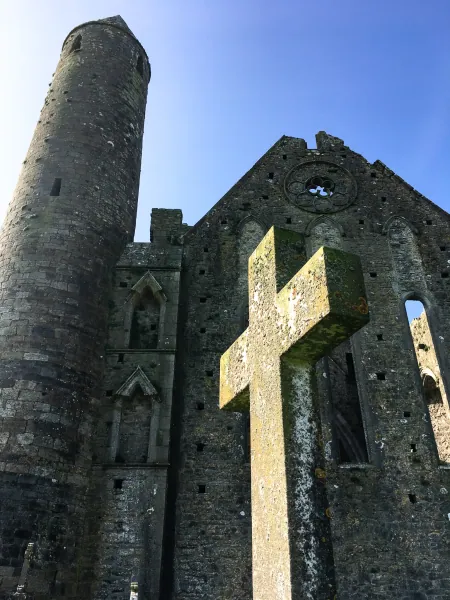 Stone cross before the round tower