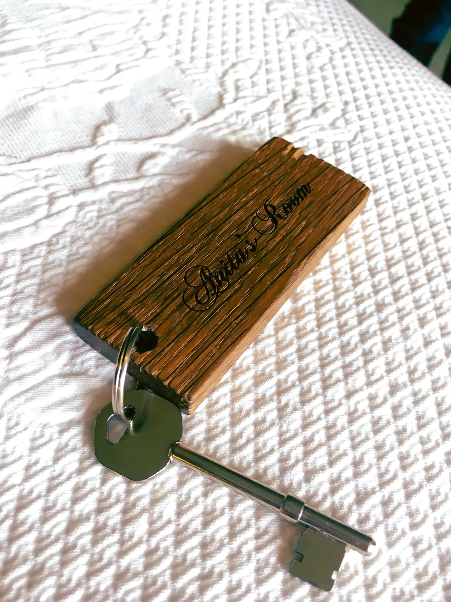 Wooden room key fob on the bed