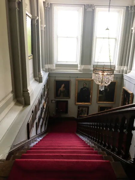 Red-carpet staircase with portraits