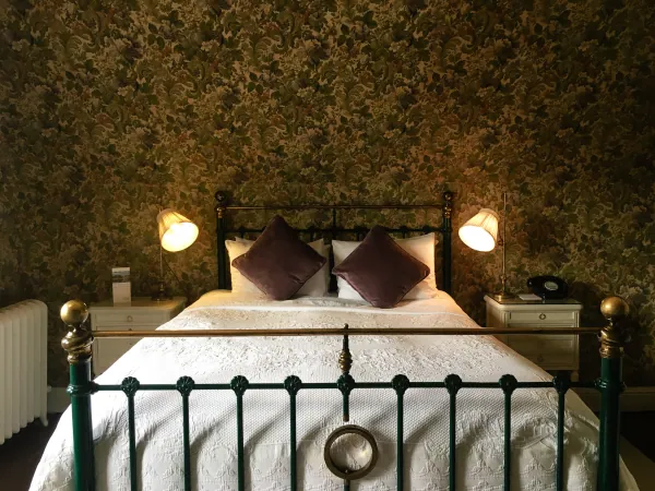 Brass bed in a floral-papered room