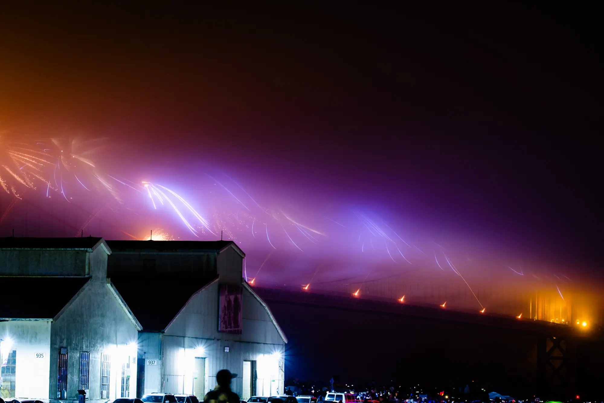 Purple trails streaking along the Golden Gate Bridge deck in the fog