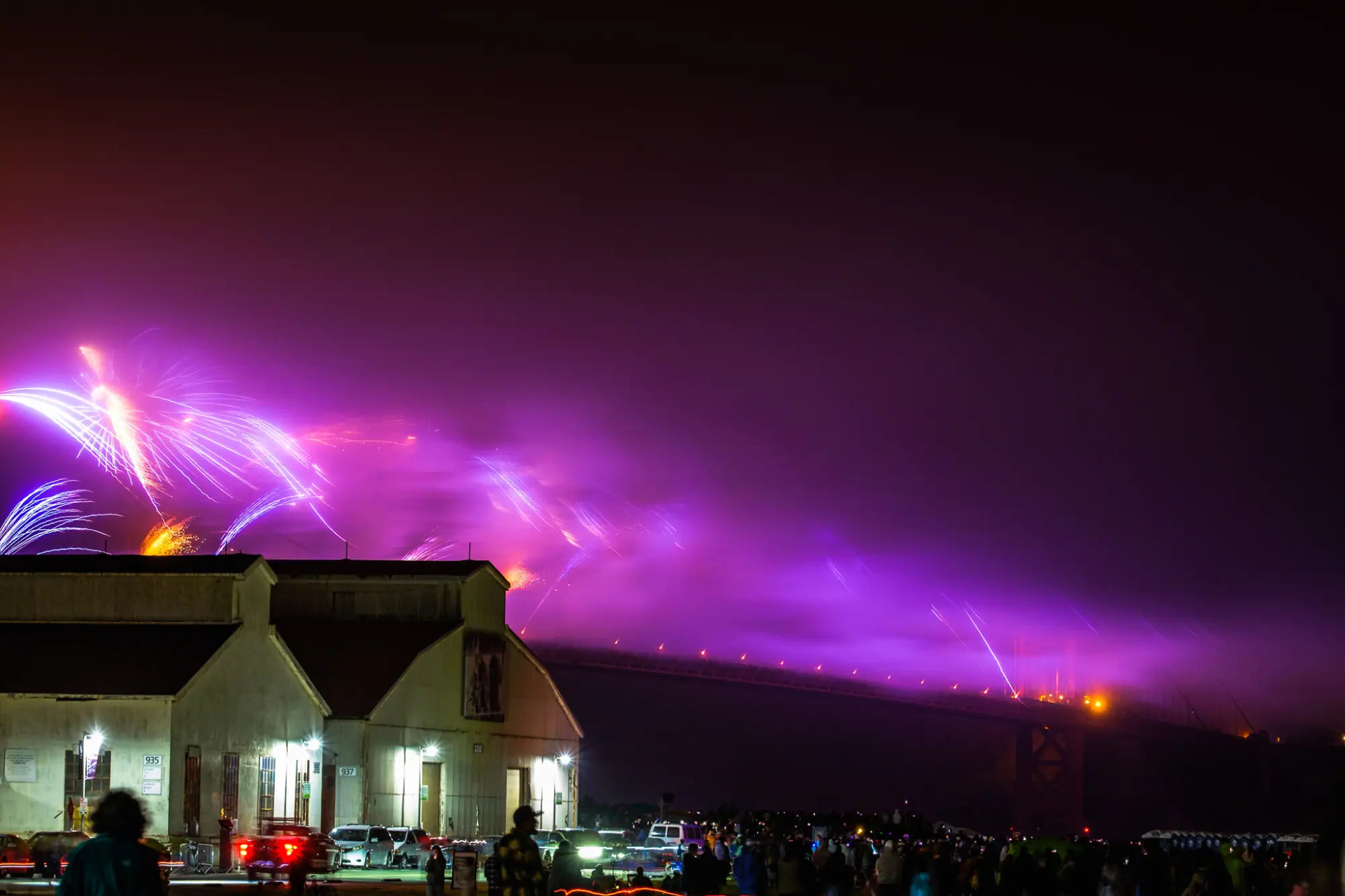 Purple fireworks along the bridge beyond the hangars