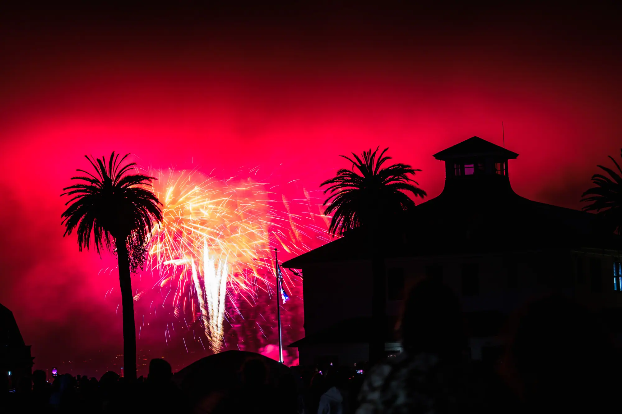 A pink and gold burst beside the palms and a cupola